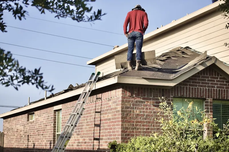 Professional roofer working on a residential roof in Neely Farm